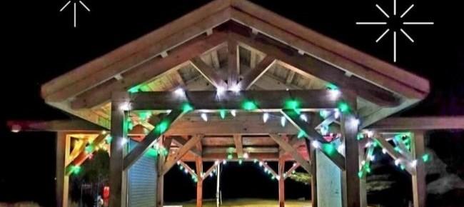Gazebo lit with colorful string lights against a dark background.